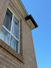 DH-IPC-HDW3667EM-S-IL-ANZ real installation - wide view of the camera installed beneath a second-storey eave; camera installation example, not the full kit contents