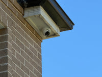 DH-IPC-HDW3667EM-S-IL-ANZ real installation - close-up of the white turret camera mounted beneath an eave; camera installation example, not the full kit contents