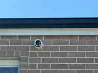 DH-IPC-HDW3849H-AS-PV-ANZ-S2 real installation - front view of the white turret camera installed on an exterior brick wall; camera installation example, not the full kit contents
