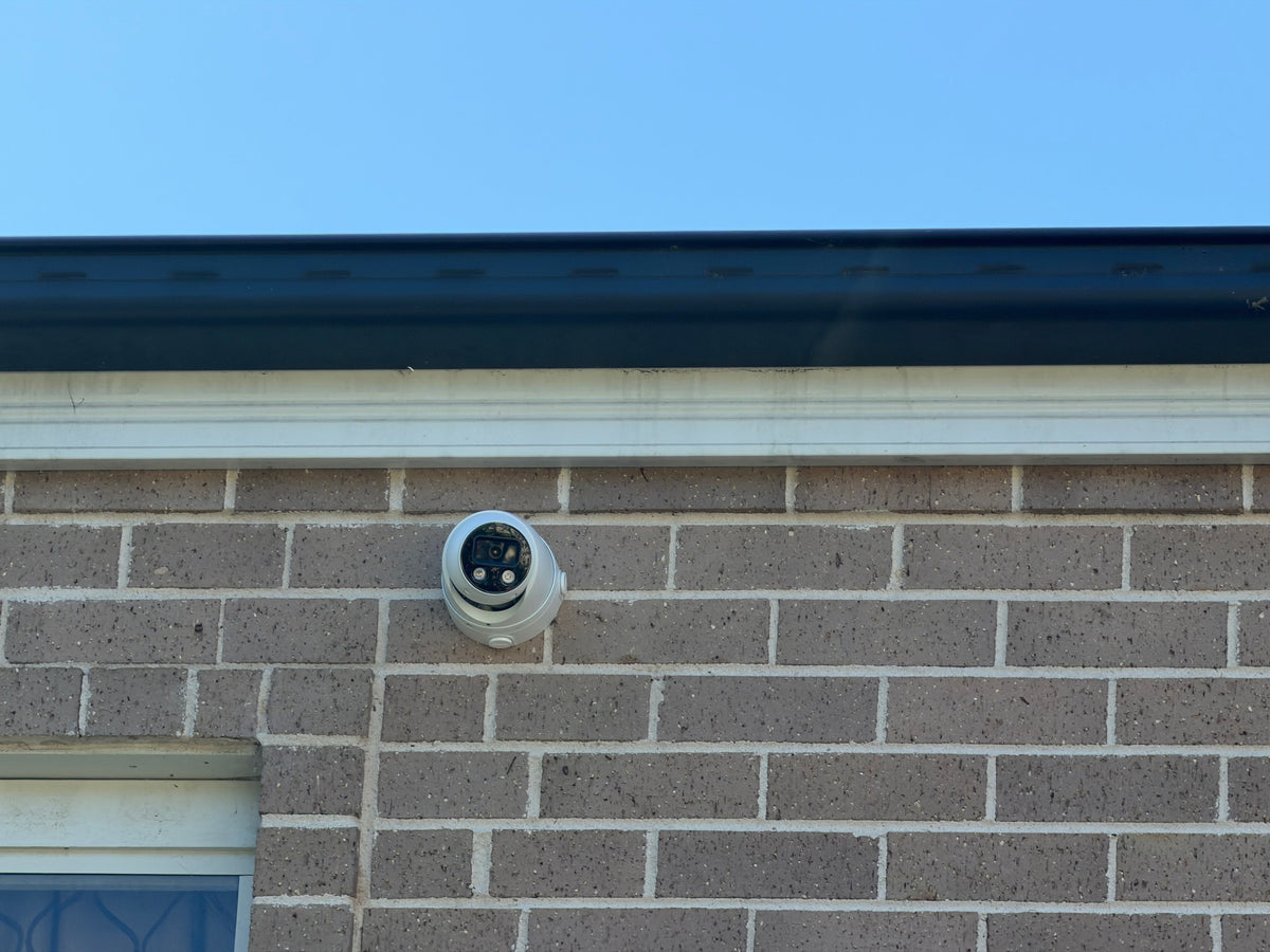 DH-IPC-HDW3849H-AS-PV-ANZ-S2 real installation - front view of the white turret camera installed on an exterior brick wall; camera installation example, not the full kit contents