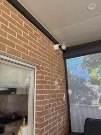 DS-2CD2387G3-LIS2UY/SL real installation - wider view of the white turret camera installed beneath a covered patio